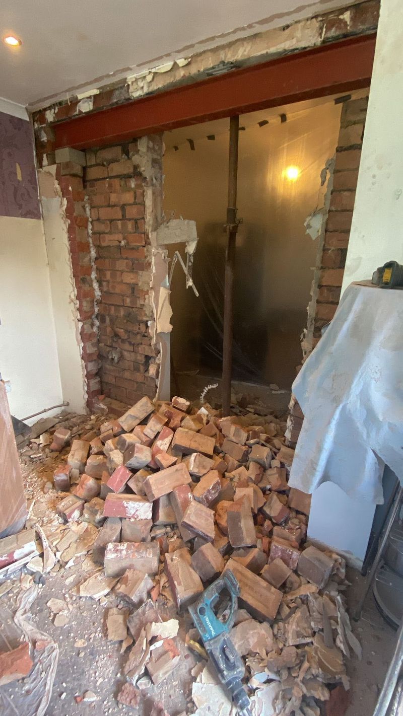 Brickwork taken out beneath a new steel beam during a knock-through